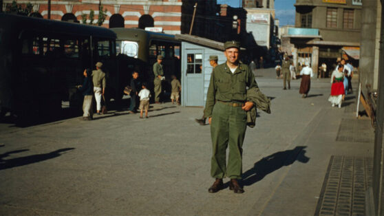 Utah 213th Field Artillery Battalion photographs beside a veteran interview